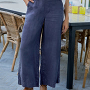 Person wearing navy wide-leg pants and a white top in an outdoor setting.