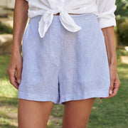 Person wearing light blue striped shorts and a white shirt in an outdoor setting