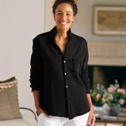 Woman wearing a black shirt and white pants in a living room setting