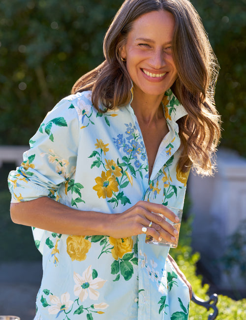 Woman wearing a floral shirt with a blurred outdoor background, view 4