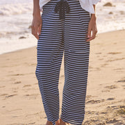 Person wearing blue and white striped pants on a beach.