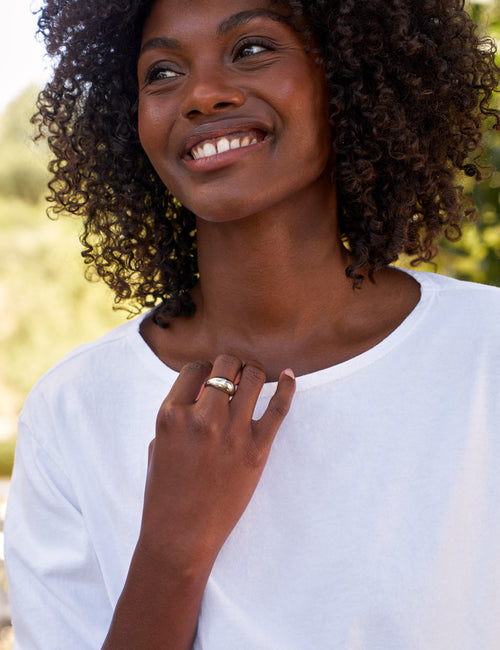 Woman wearing a white shirt with a blurred natural background, view 3