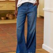 Person wearing blue flared jeans in a kitchen setting