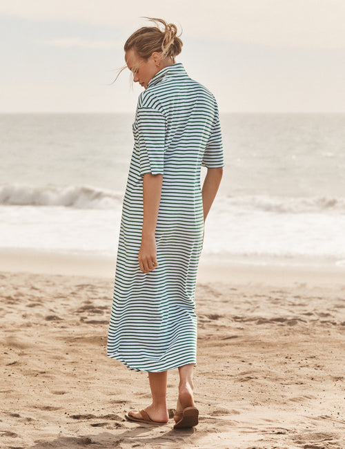 Woman wearing a striped dress on a beach, view 3