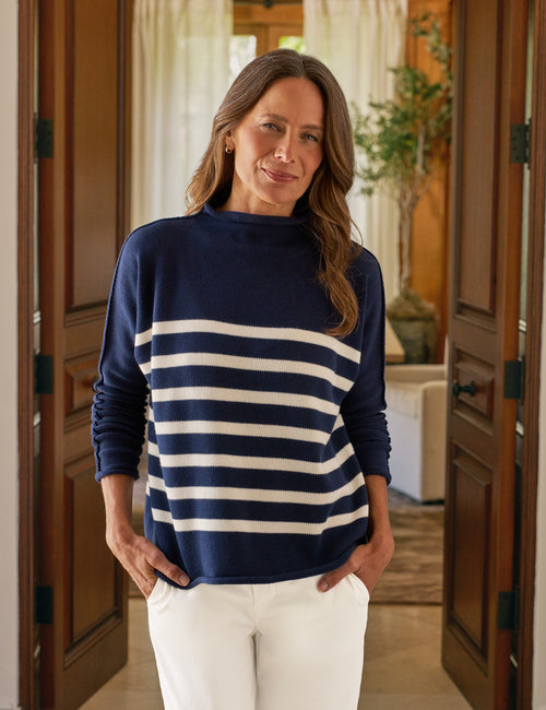 Woman wearing a navy and white striped sweater in a home setting, front view