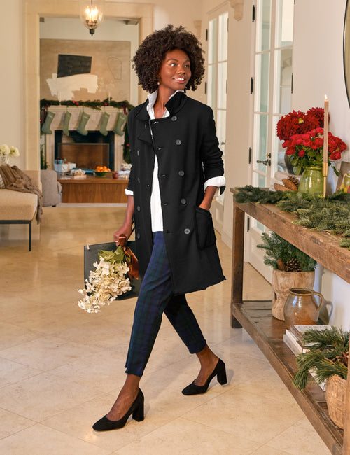 Woman in a black coat in a decorated living room., view 4