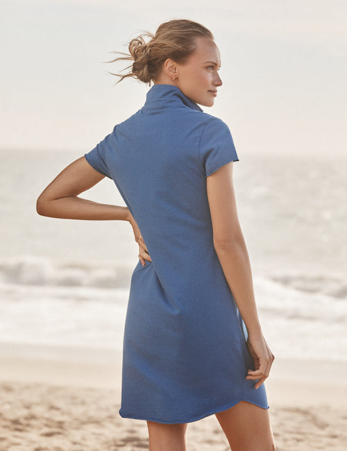 Woman wearing a blue dress on a beach, alternate view