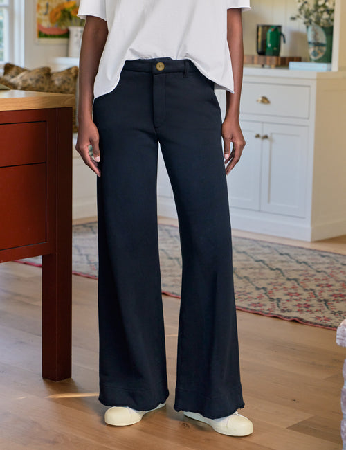Person wearing navy wide-leg pants in a home setting, front view