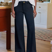 Person wearing navy wide-leg pants in a home setting