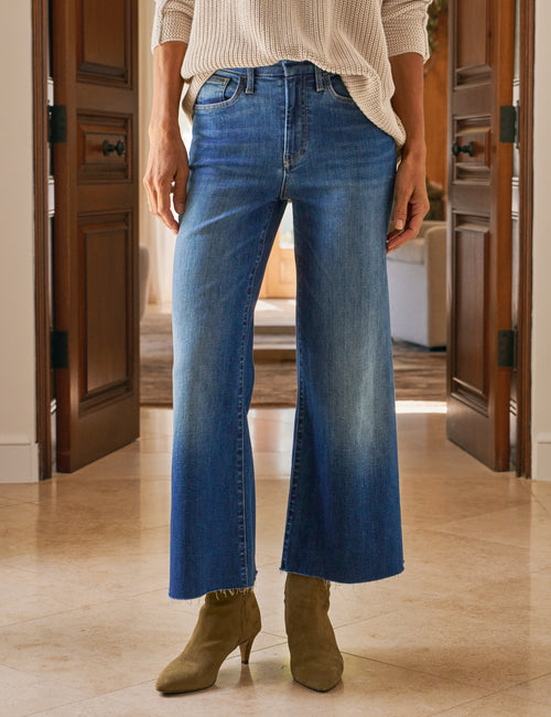 Person wearing blue jeans and camel boots in a home setting, front view