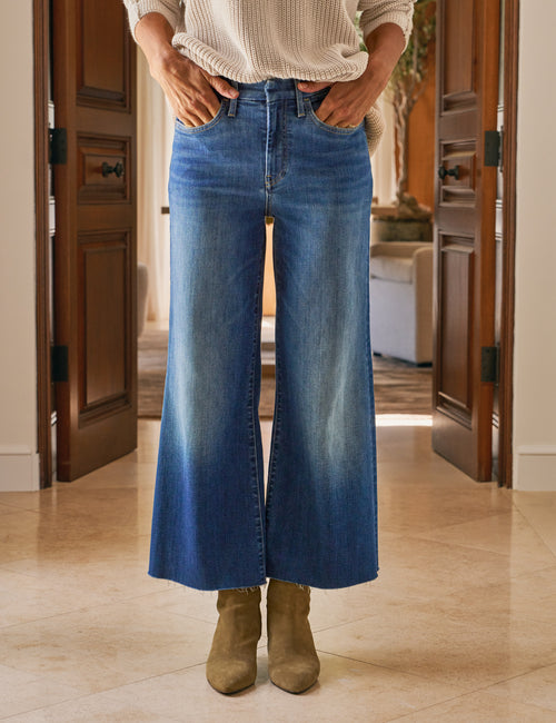 Person wearing blue jeans and brown boots indoors., view 4
