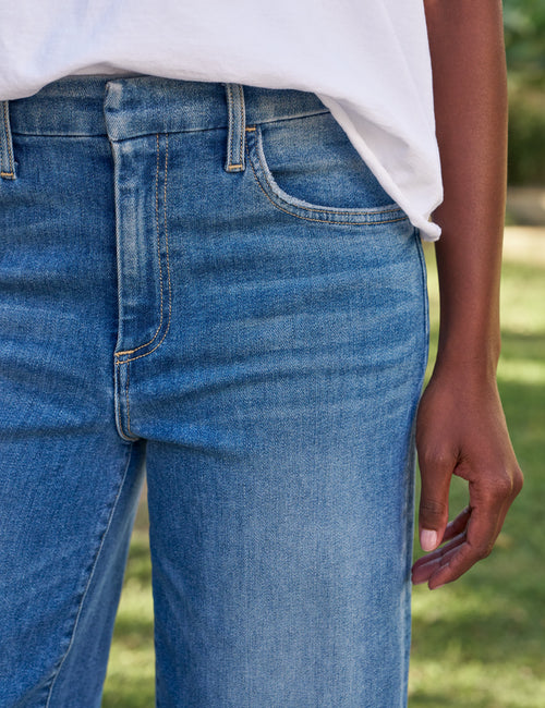 Person wearing blue jeans with a blurred background, view 3