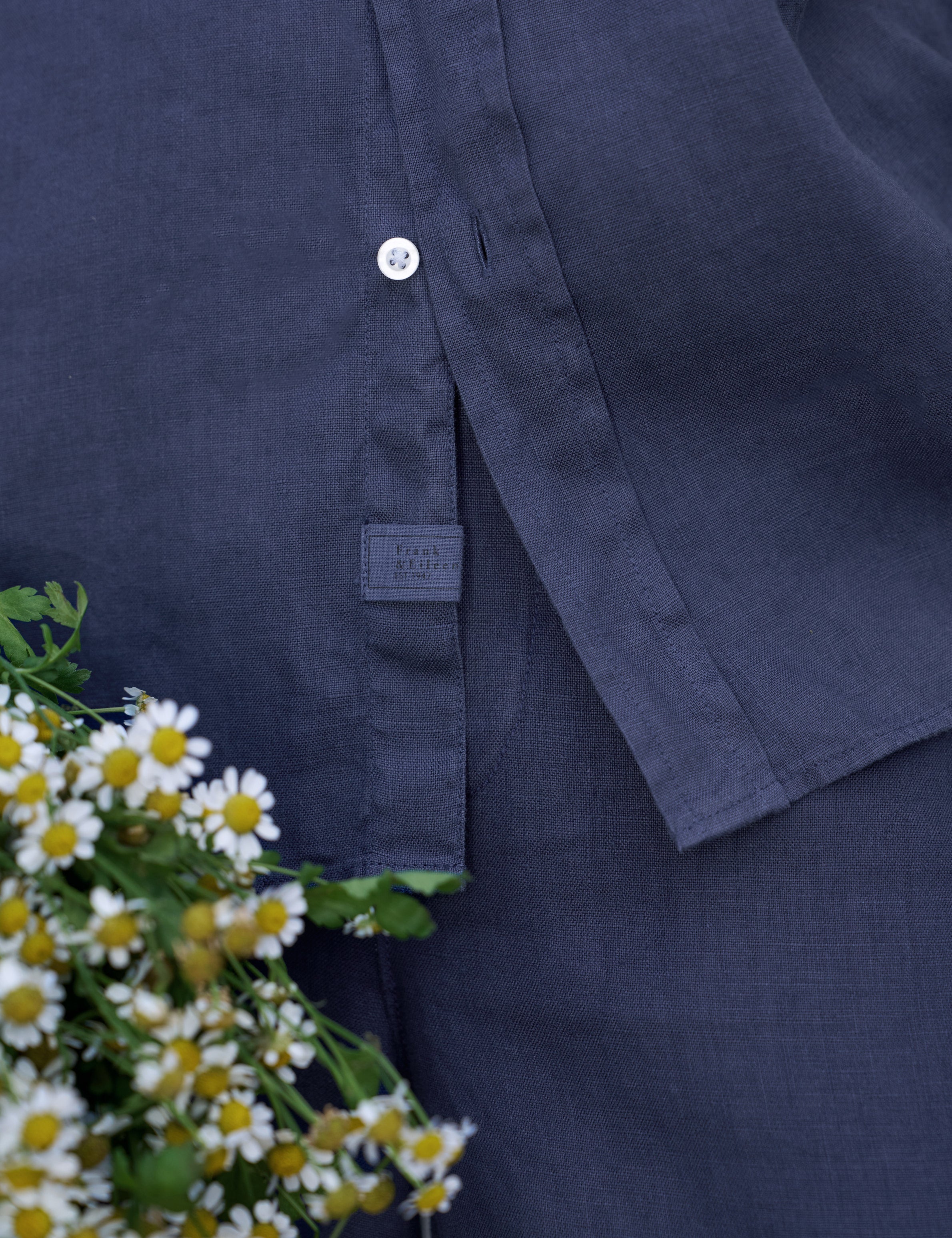 Navy shirt with a brand label next to white flowers
