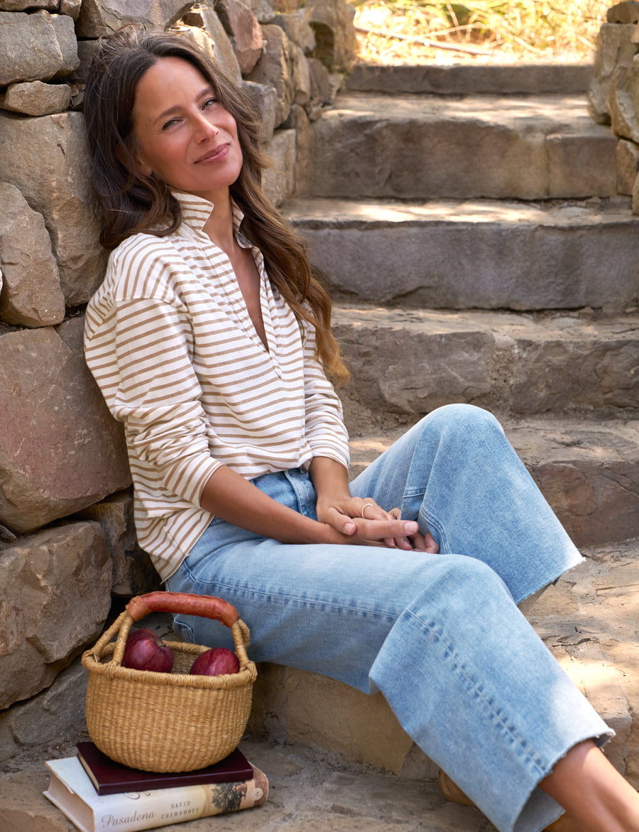Woman sitting on stone steps with a basket of apples and books