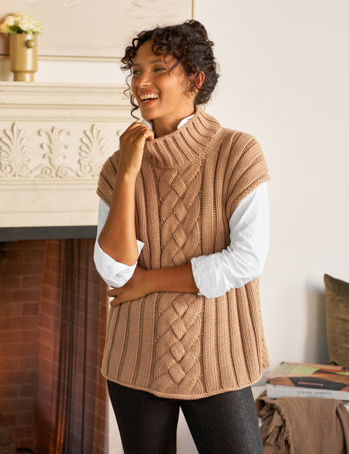 Woman wearing a beige knitted vest indoors, front view