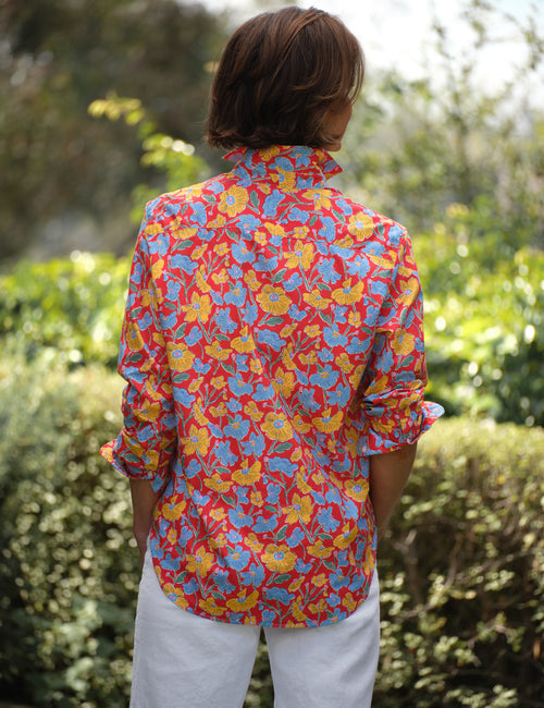 Person wearing a colorful floral shirt standing in a garden, view 4