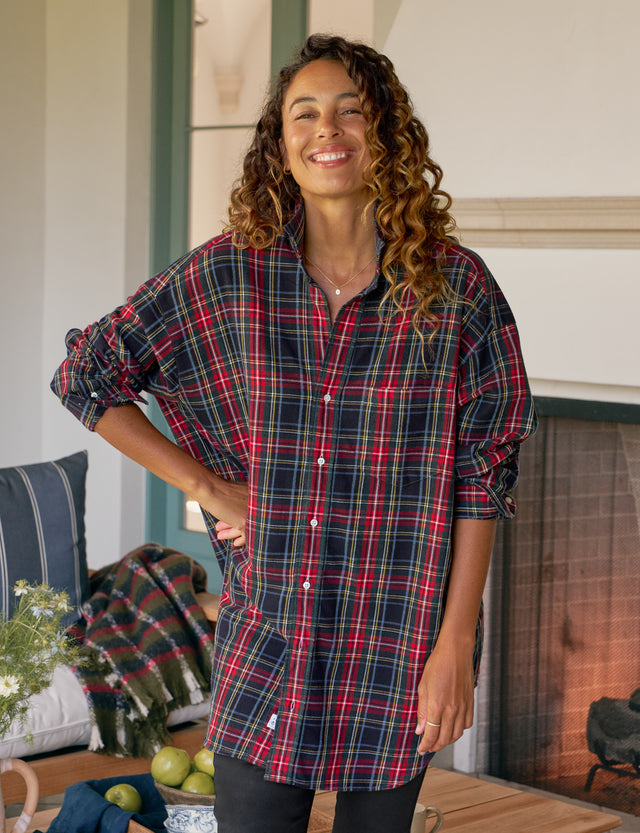 Woman wearing a plaid shirt standing in a cozy living room.