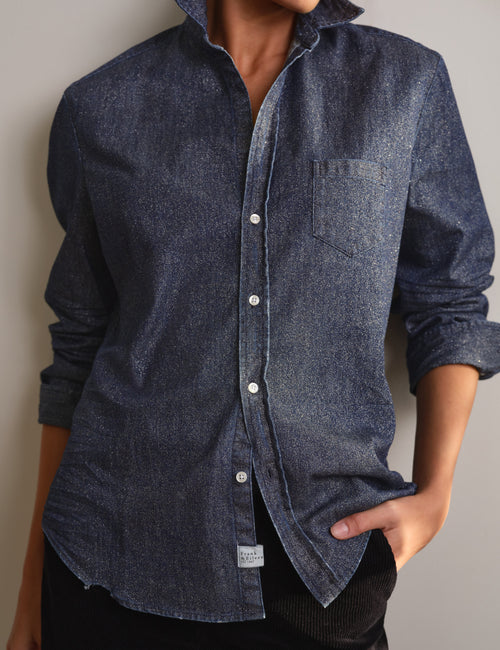 A woman wearing a dark blue glitter denim long-sleeve button-down shirt with a chest pocket, shown from the neck down against a plain light gray background., view 4