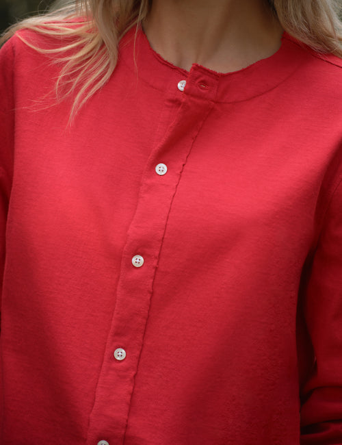 Close-up of a red cardigan worn by a person with blonde hair., view 5
