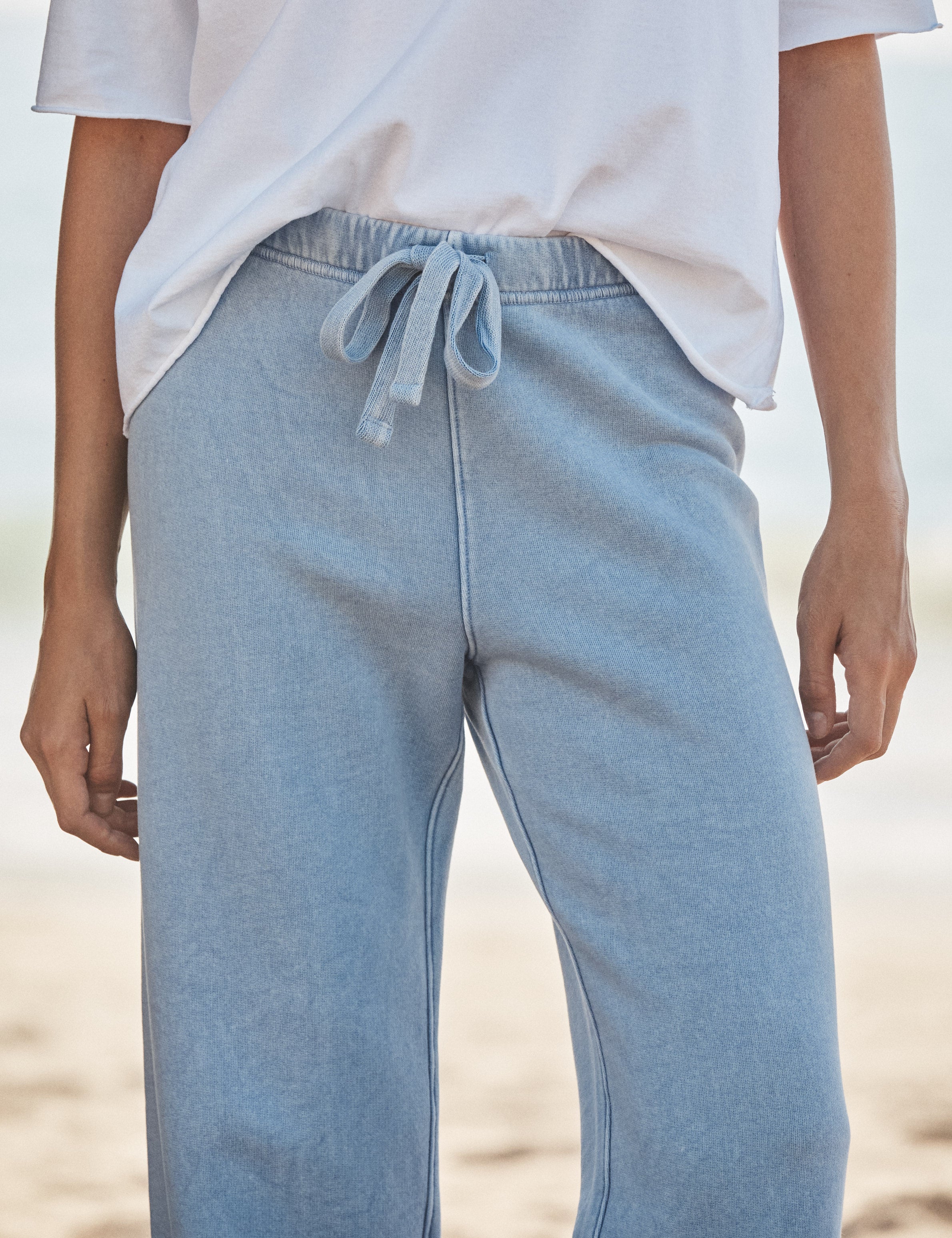 Light blue sweatpants worn by a person on a beach., view 3
