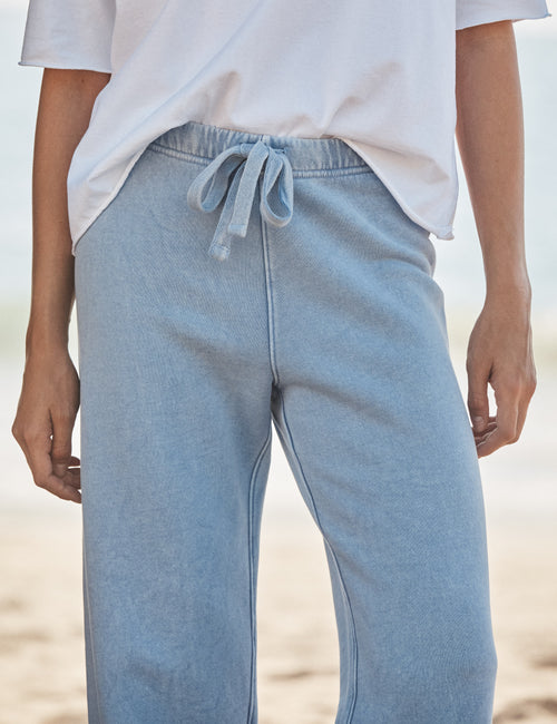 Light blue sweatpants worn by a person on a beach., view 3