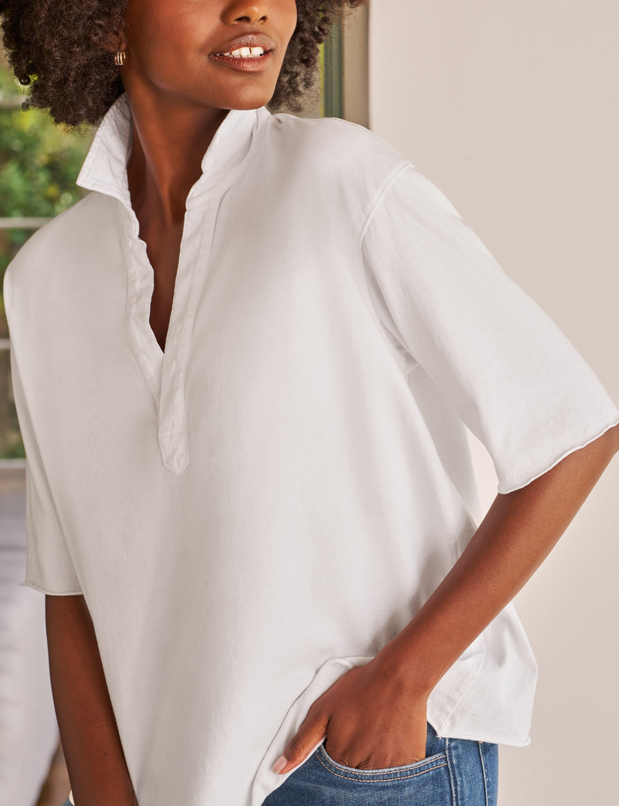 Woman wearing a white oversized shirt with a neutral background