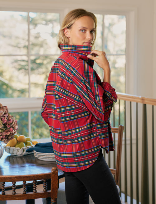 Woman wearing a red plaid button-up in a home setting, alternate view