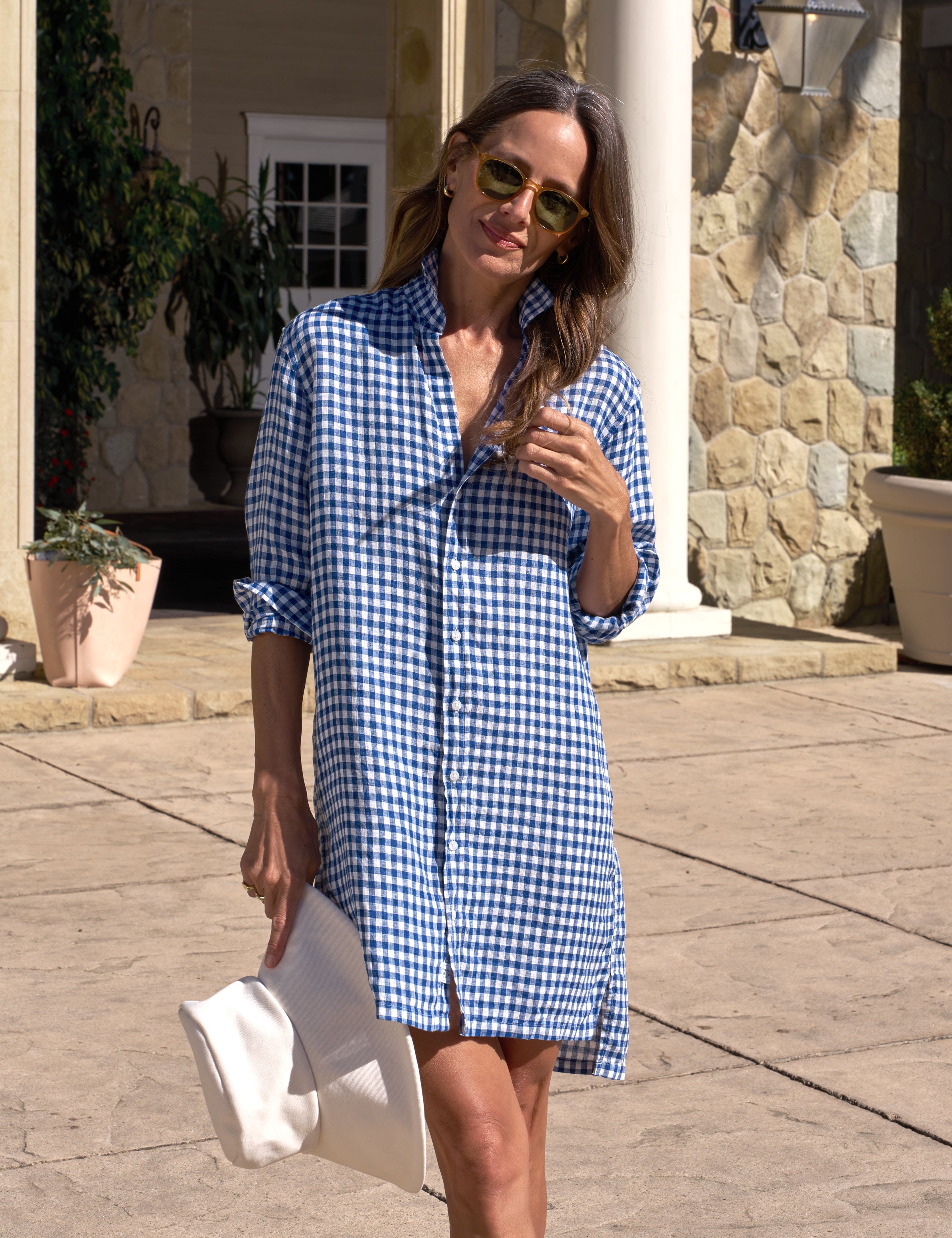 Woman wearing a blue and white checkered dress outdoors.