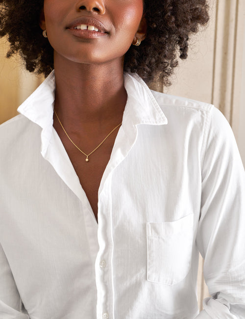 Woman wearing a white shirt with a neutral background, view 3