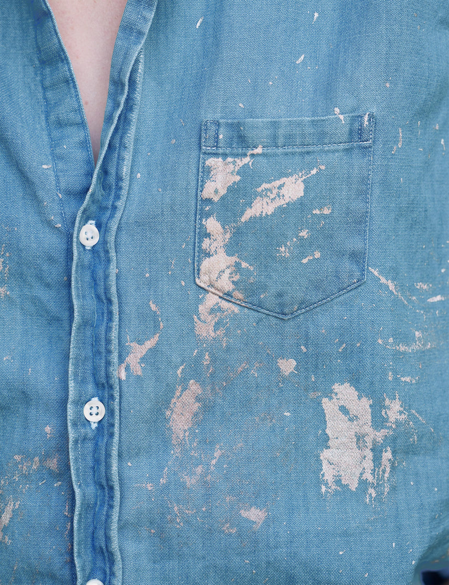 Detail of front button placket and pocket on person wearing Gold Paint Splatter Frank & Eileen Eileen Relaxed Button-Up Shirt in Famous Denim