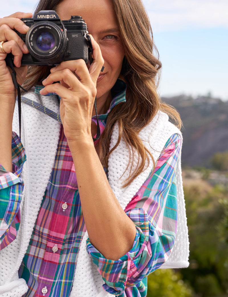 Woman holding a camera with a scenic background