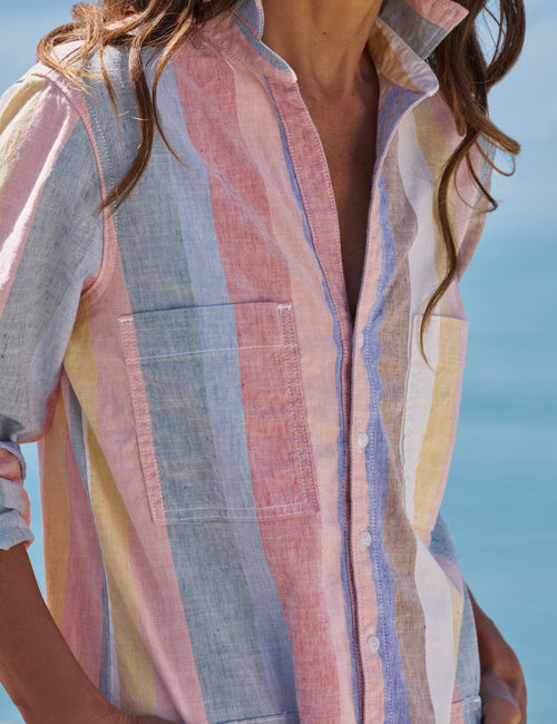 Person wearing a colorful striped shirt with a blurred background, view 3