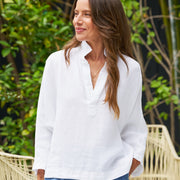 Woman in white blouse and blue shorts standing outdoors