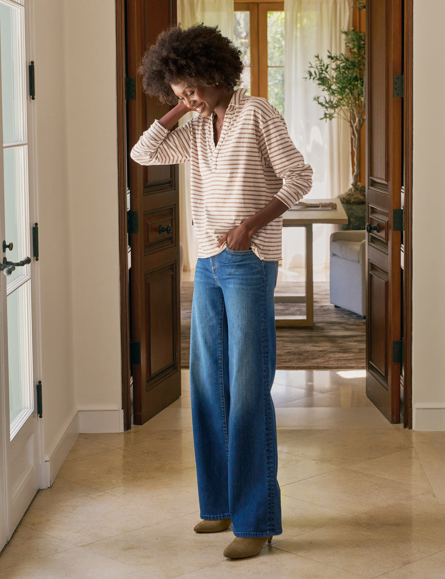 Woman adjusting her blue jeans in a home setting