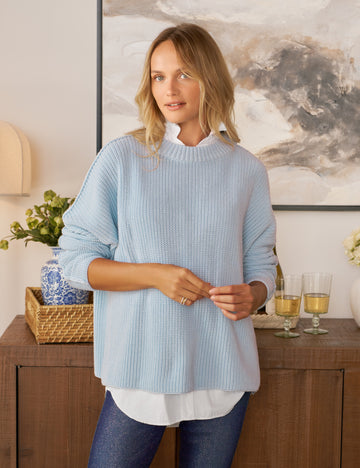 Woman wearing a light blue sweater in a home setting