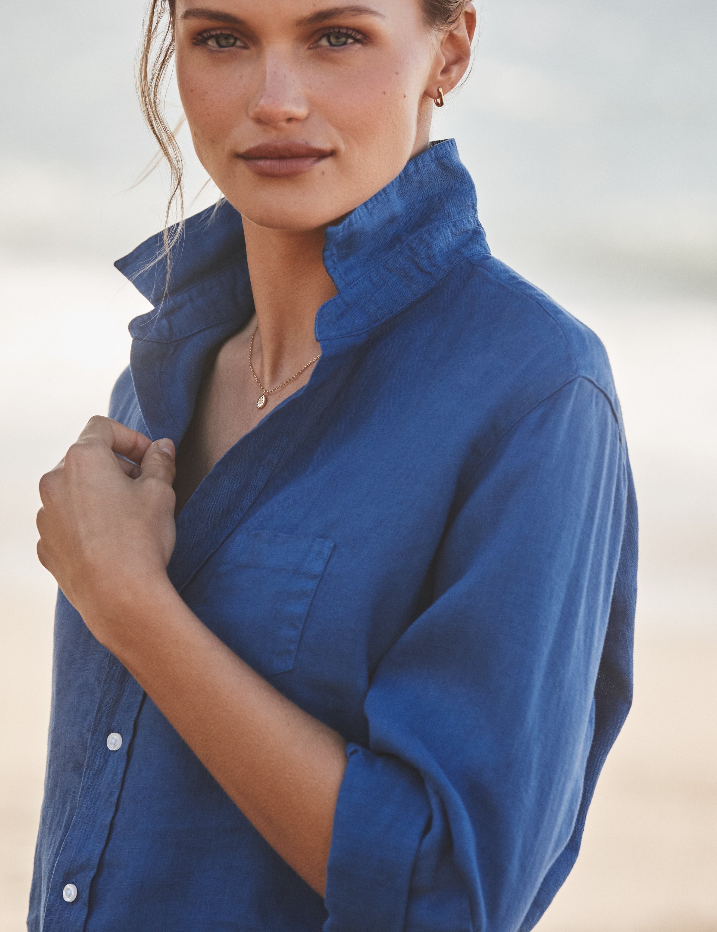 Woman wearing a blue shirt against a neutral background, view 3