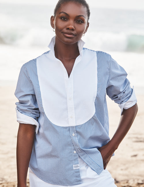 Woman wearing a blue and white striped shirt on a beach, view 3