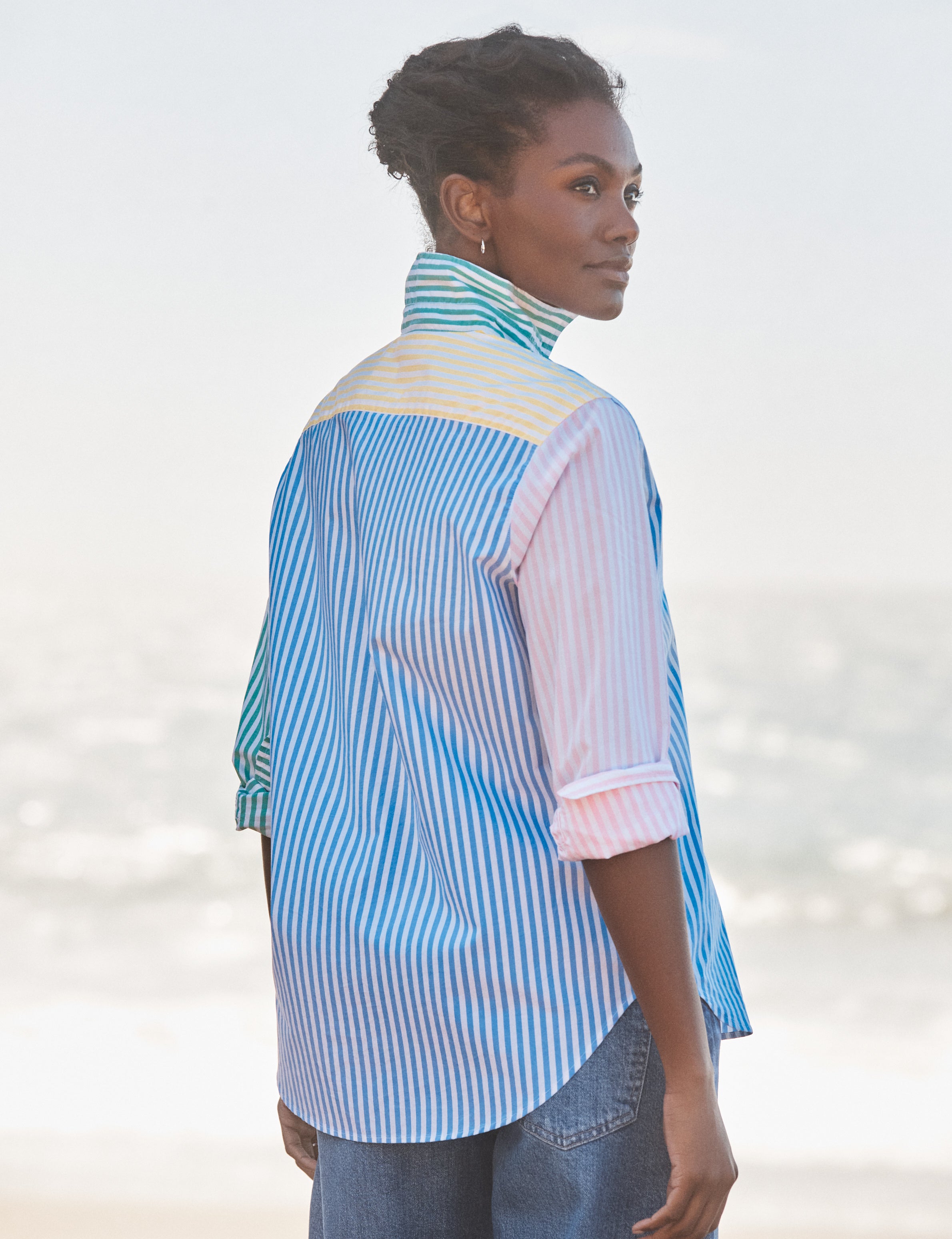 Woman wearing a colorful striped shirt with a blurred background, alternate view