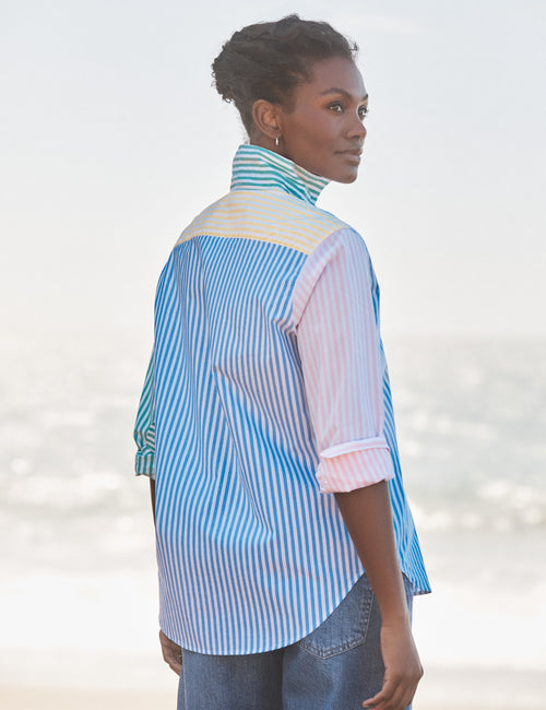 Woman wearing a colorful striped shirt with a blurred background, alternate view