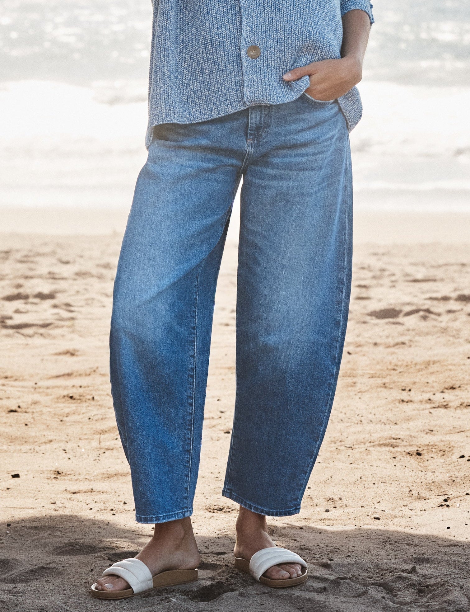 Woman wearing a blue outfit standing on a beach, front view