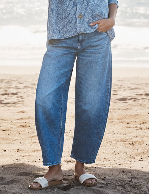 Woman wearing a blue outfit standing on a beach, front view