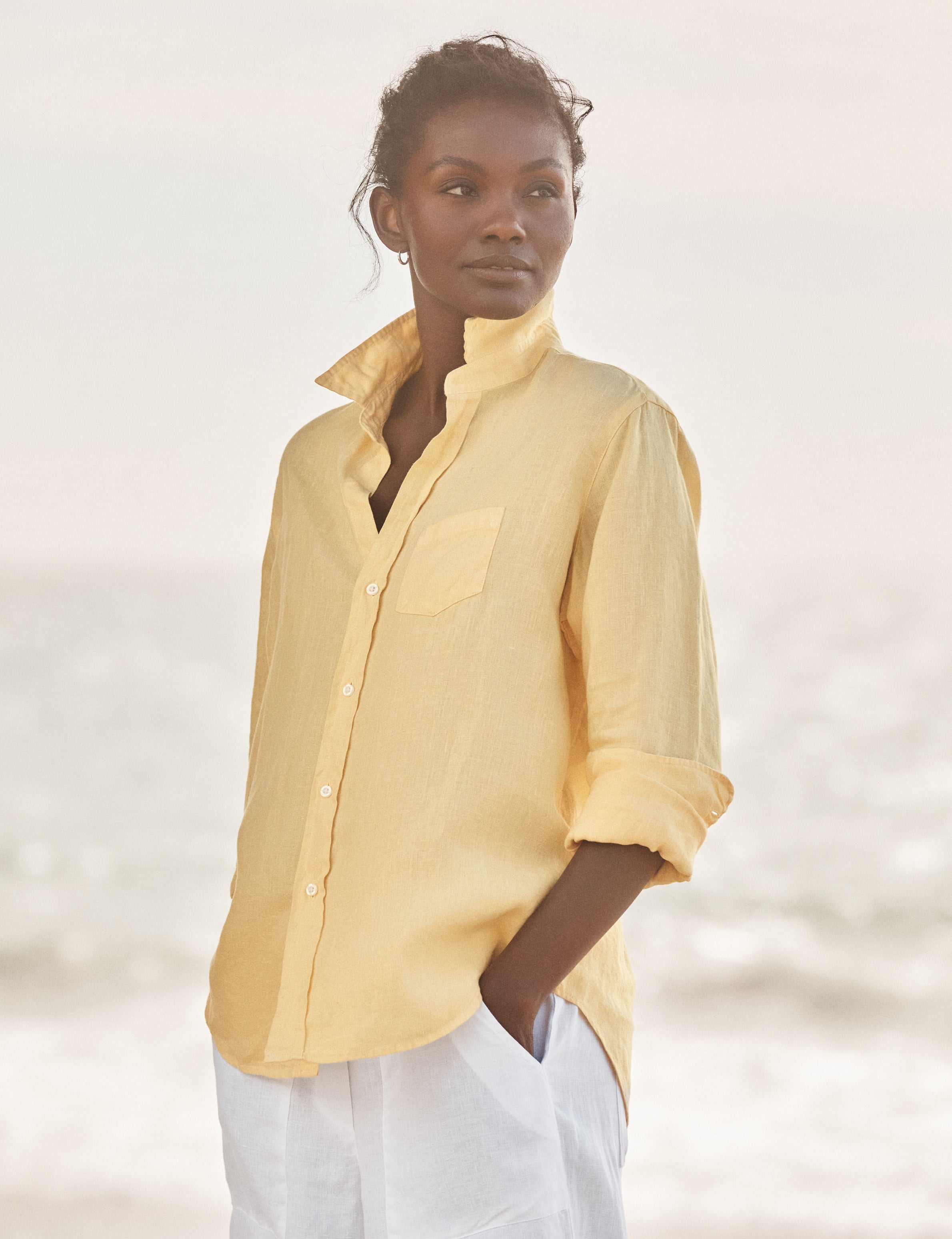 Woman wearing a yellow shirt with a blurred background, front view