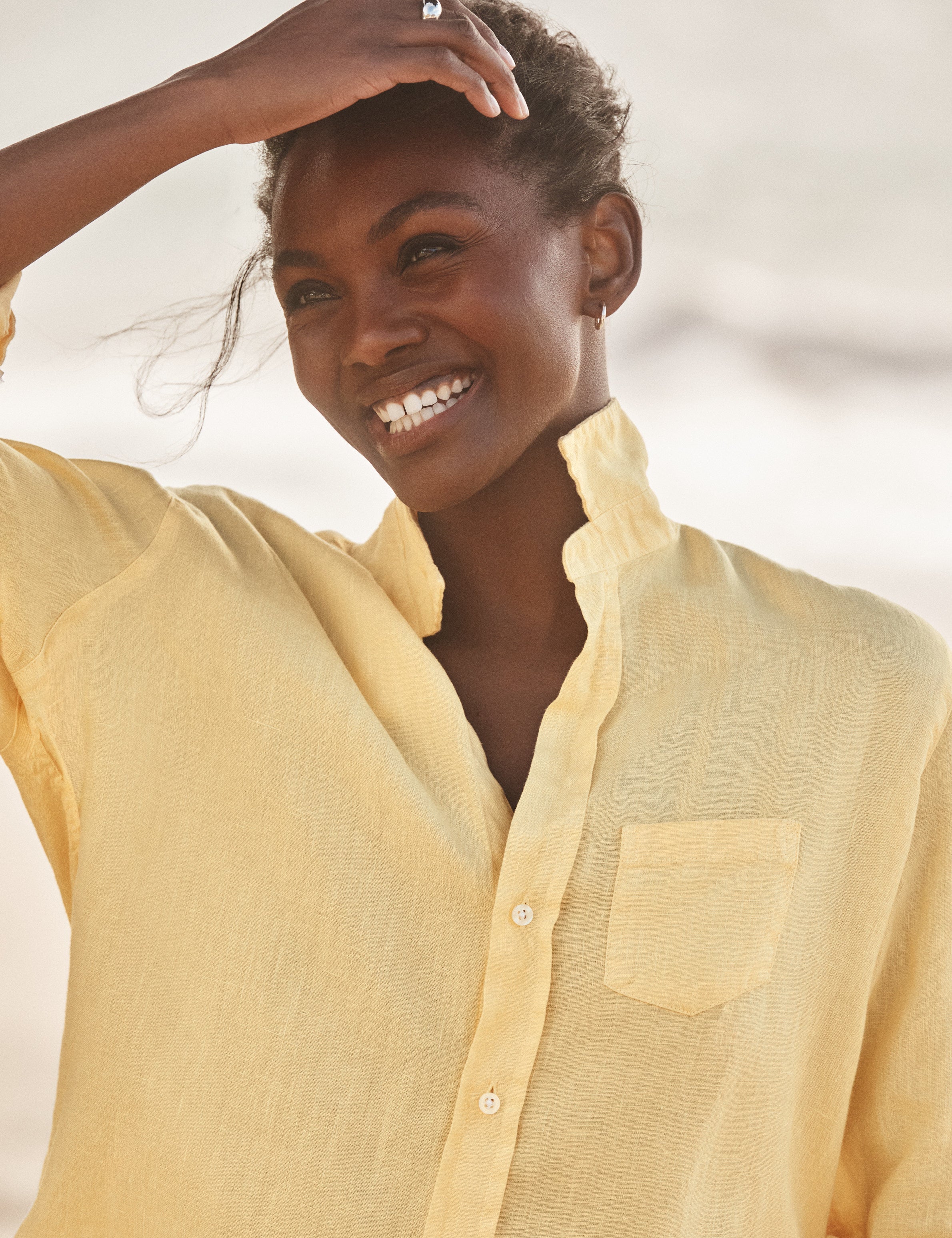 Woman wearing a yellow shirt with a blurred background, view 3