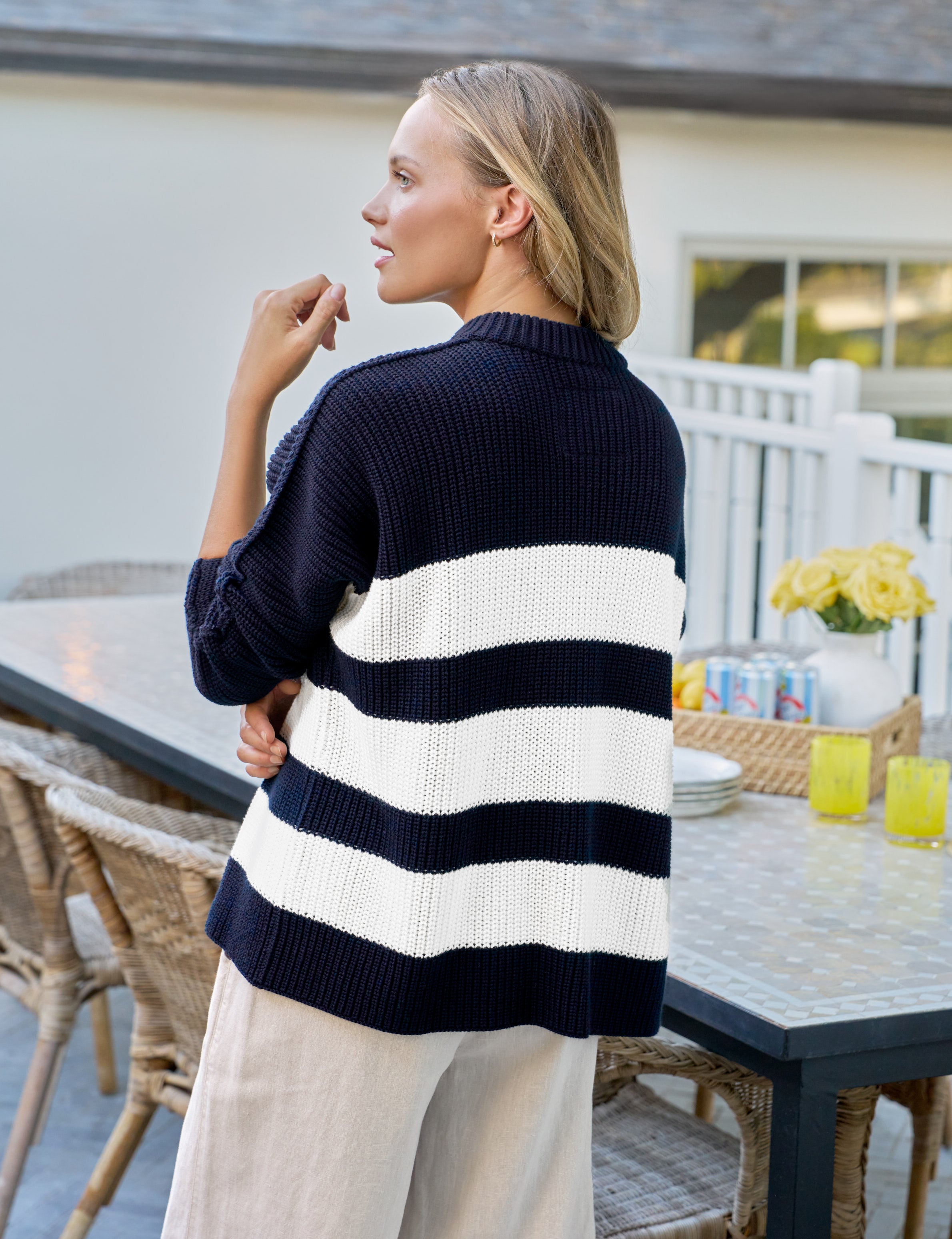 Woman wearing a navy and white striped sweater on a patio
