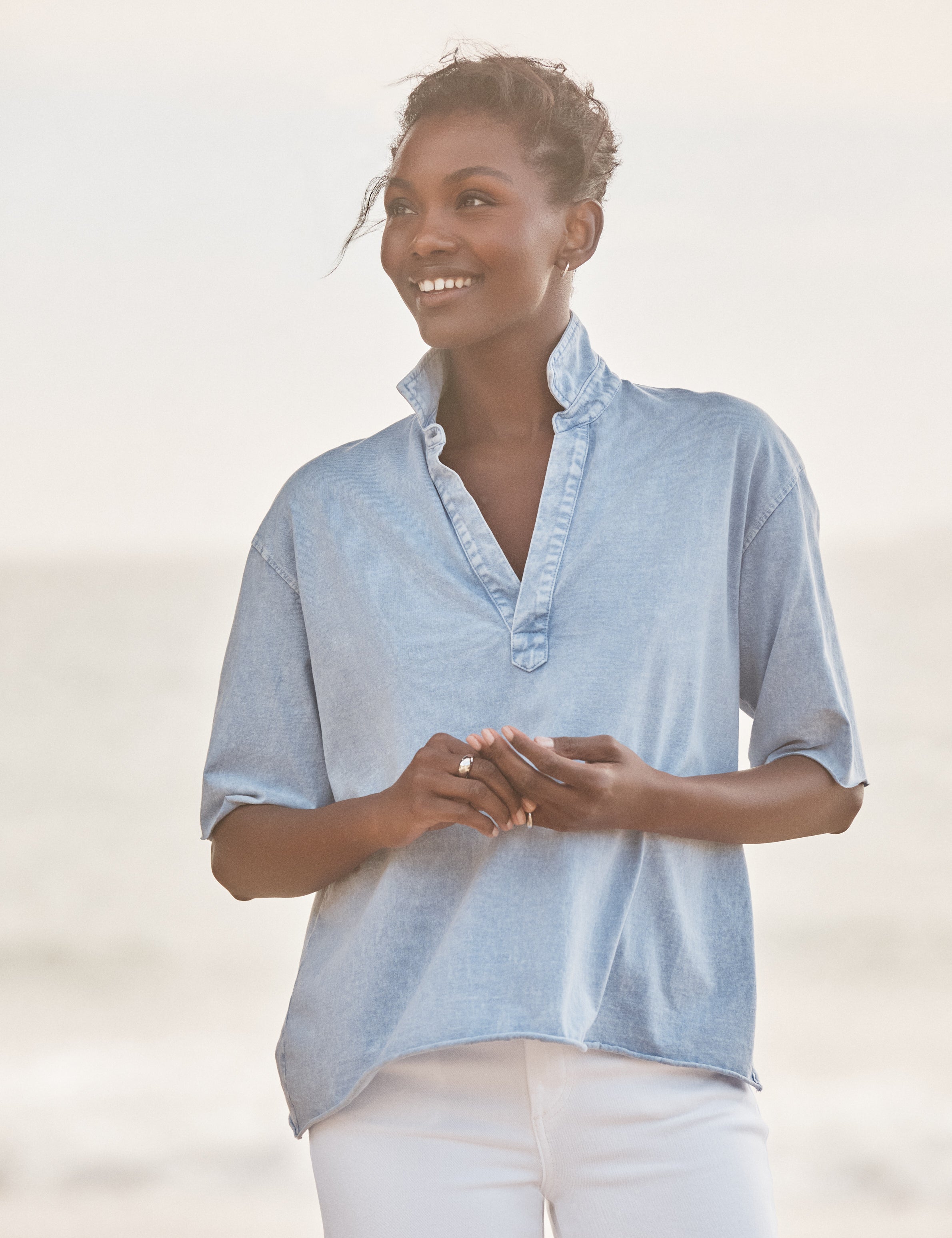 Woman wearing a light blue shirt with a blurred background, view 4