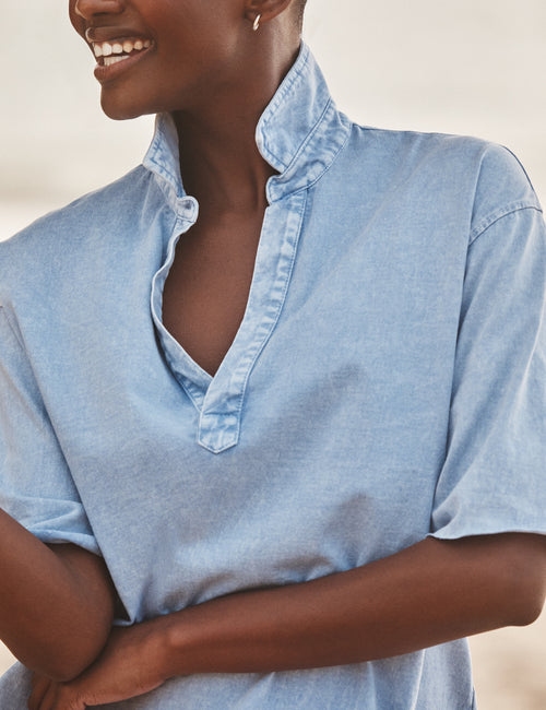 Woman wearing a light blue shirt with a neutral background, view 3