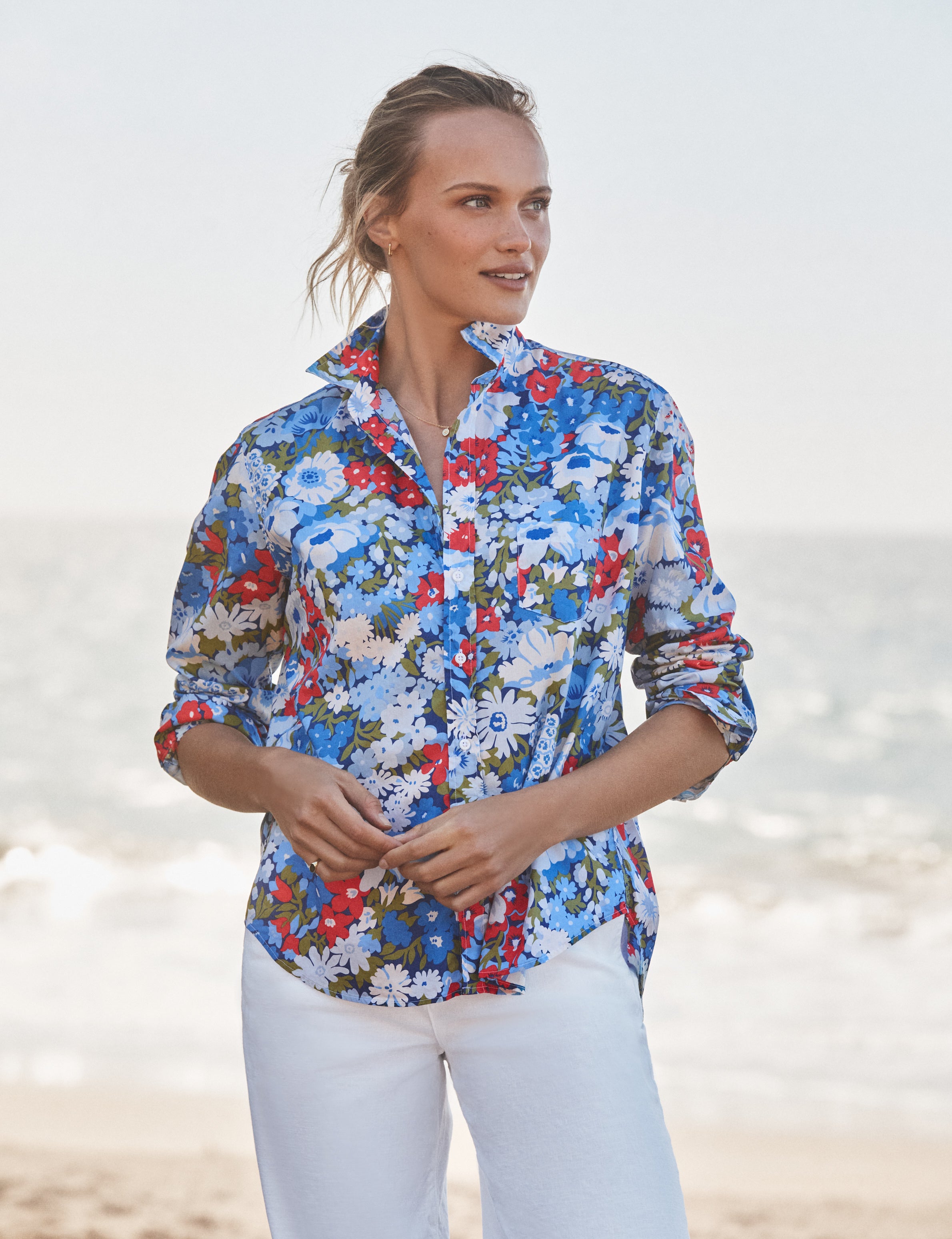 Woman wearing a colorful floral shirt on a beach, front view