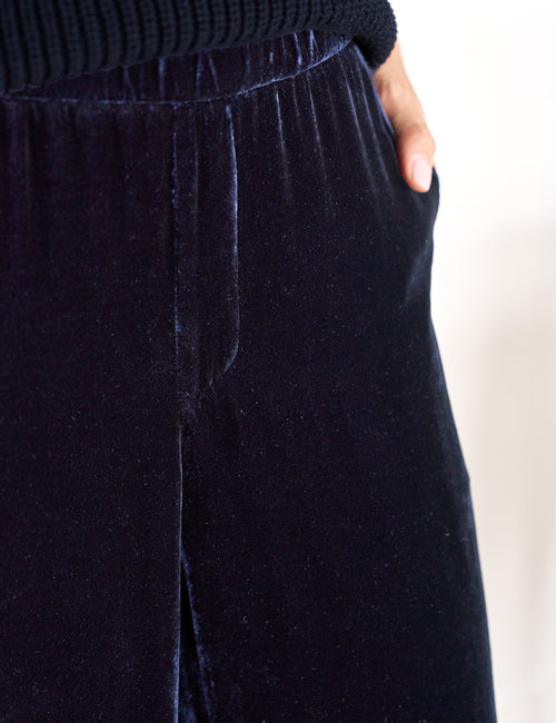 Navy velvet pants with a blurred background, view 3