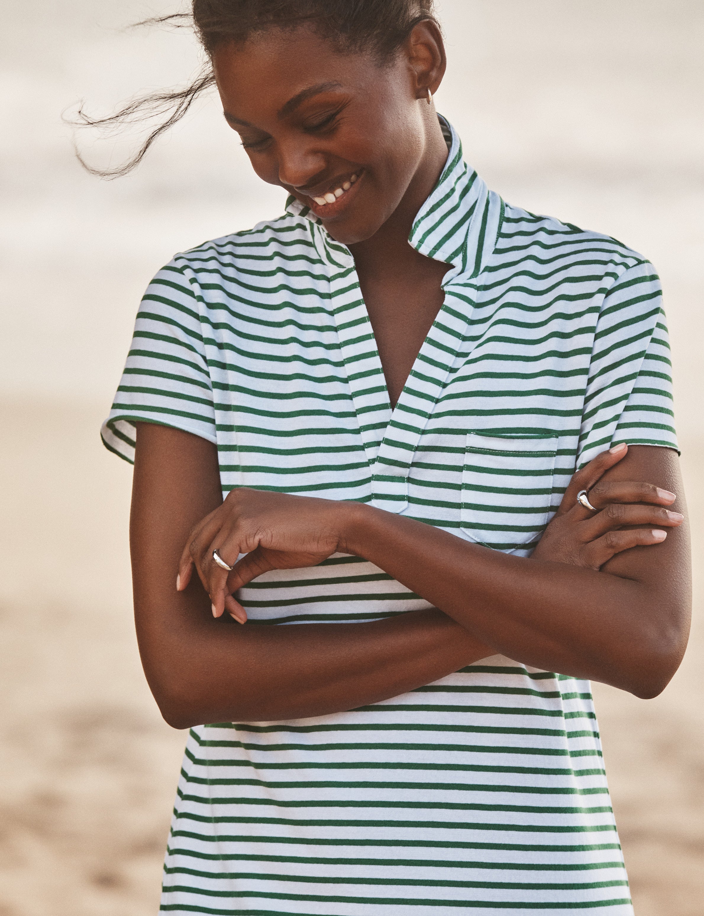 Woman wearing a green and white striped dress with a blurred background, view 3