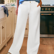 Person wearing white pants and a blue shirt in a kitchen.